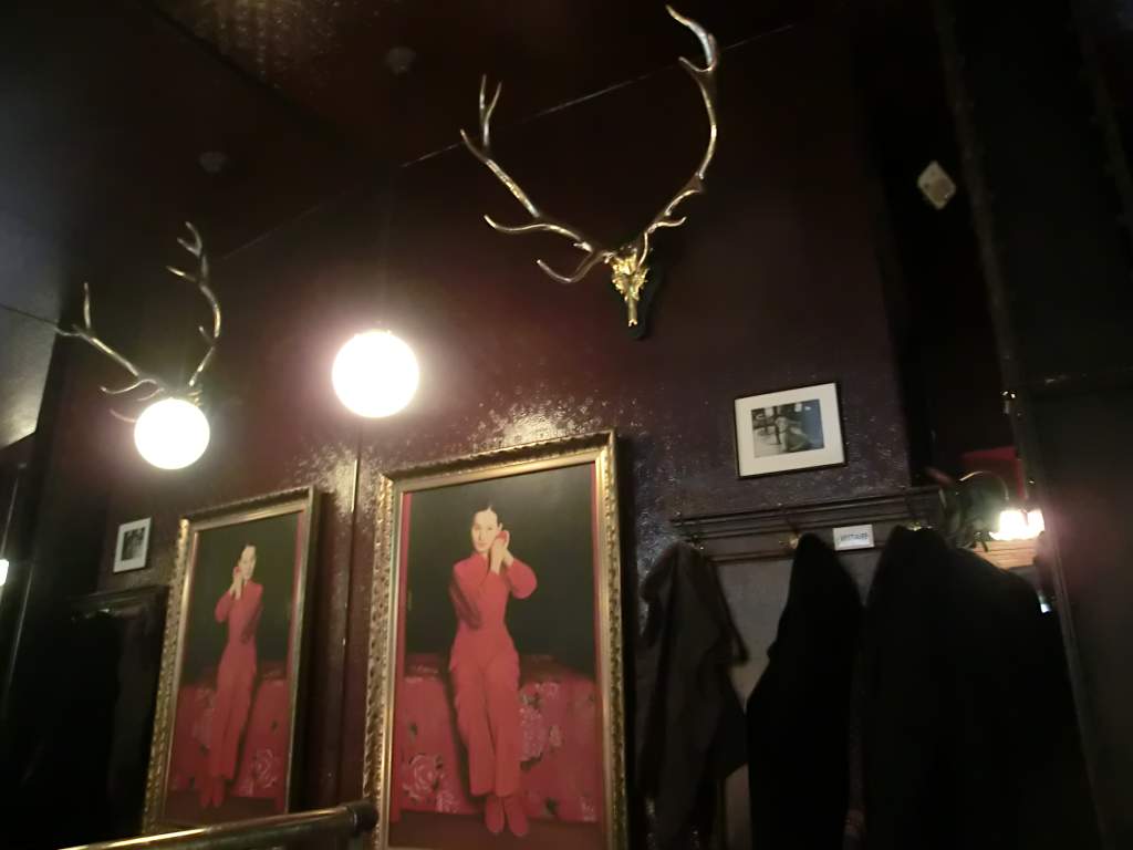 Café-Flo-Interieur: Hirschgeweihe, Globe-Lichter und ein gerahmtes Portrait