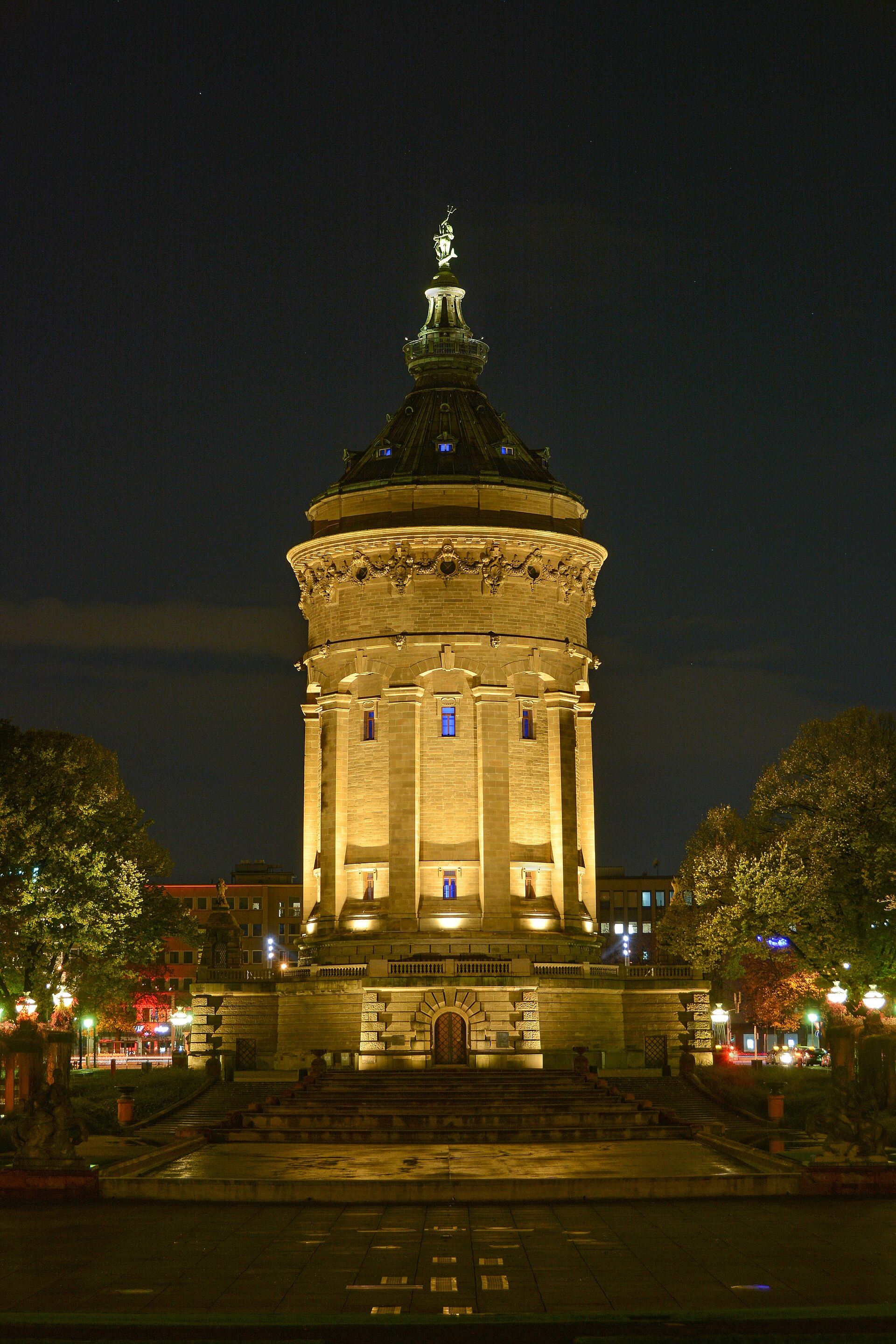 Mannheimer Wasserturm bei Abendlicht — warm beleuchtete Sandsteinfassade gegen den dunklen Himmel